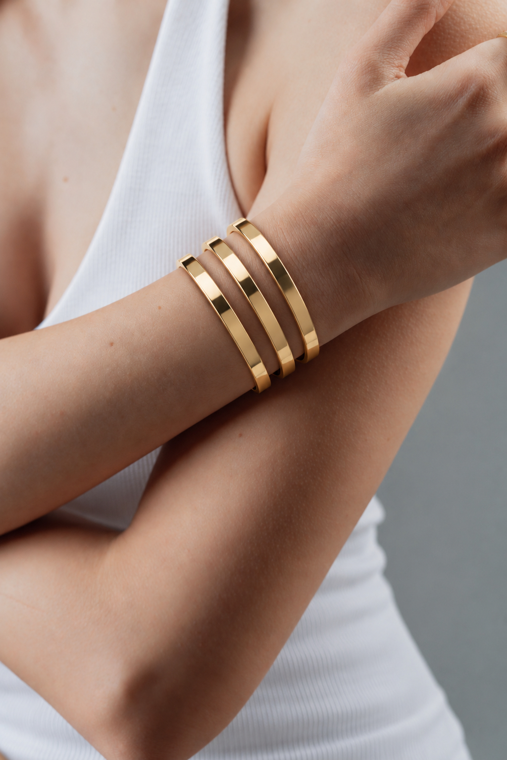 Polished gold bangles worn on a wrist