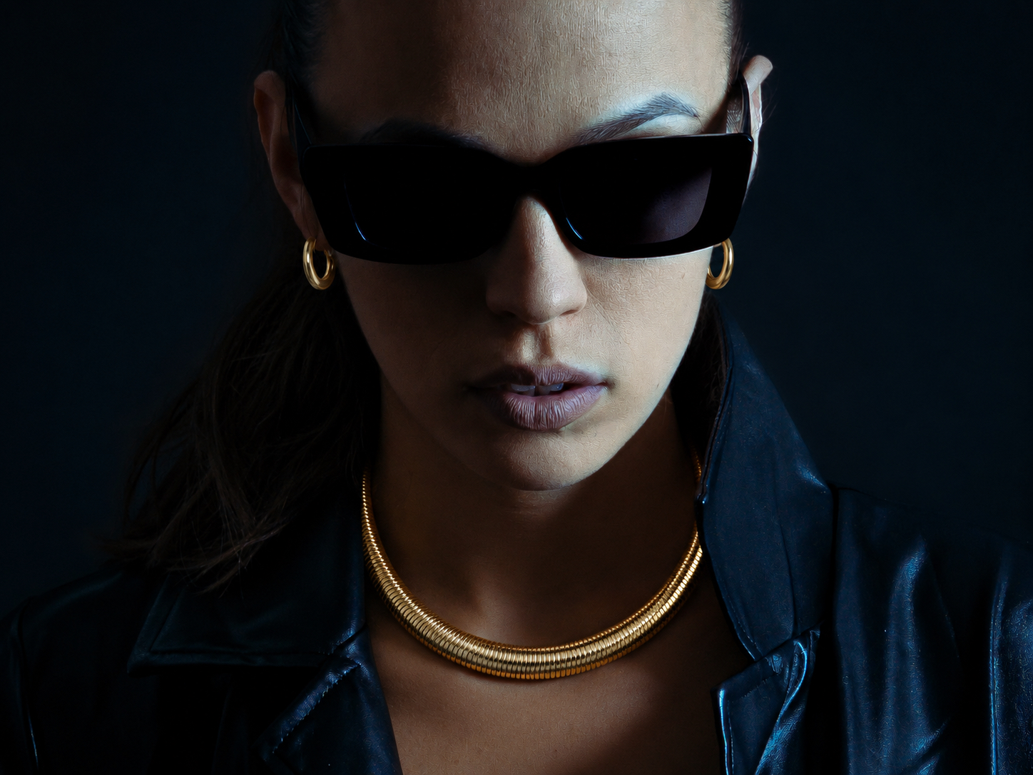 Gold collar necklace worn with black sunglasses after dark