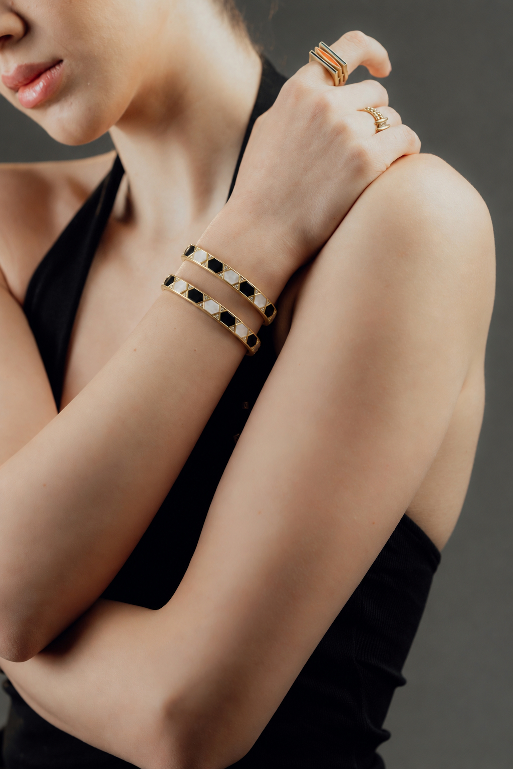 Patterned gold bangles and rings worn together