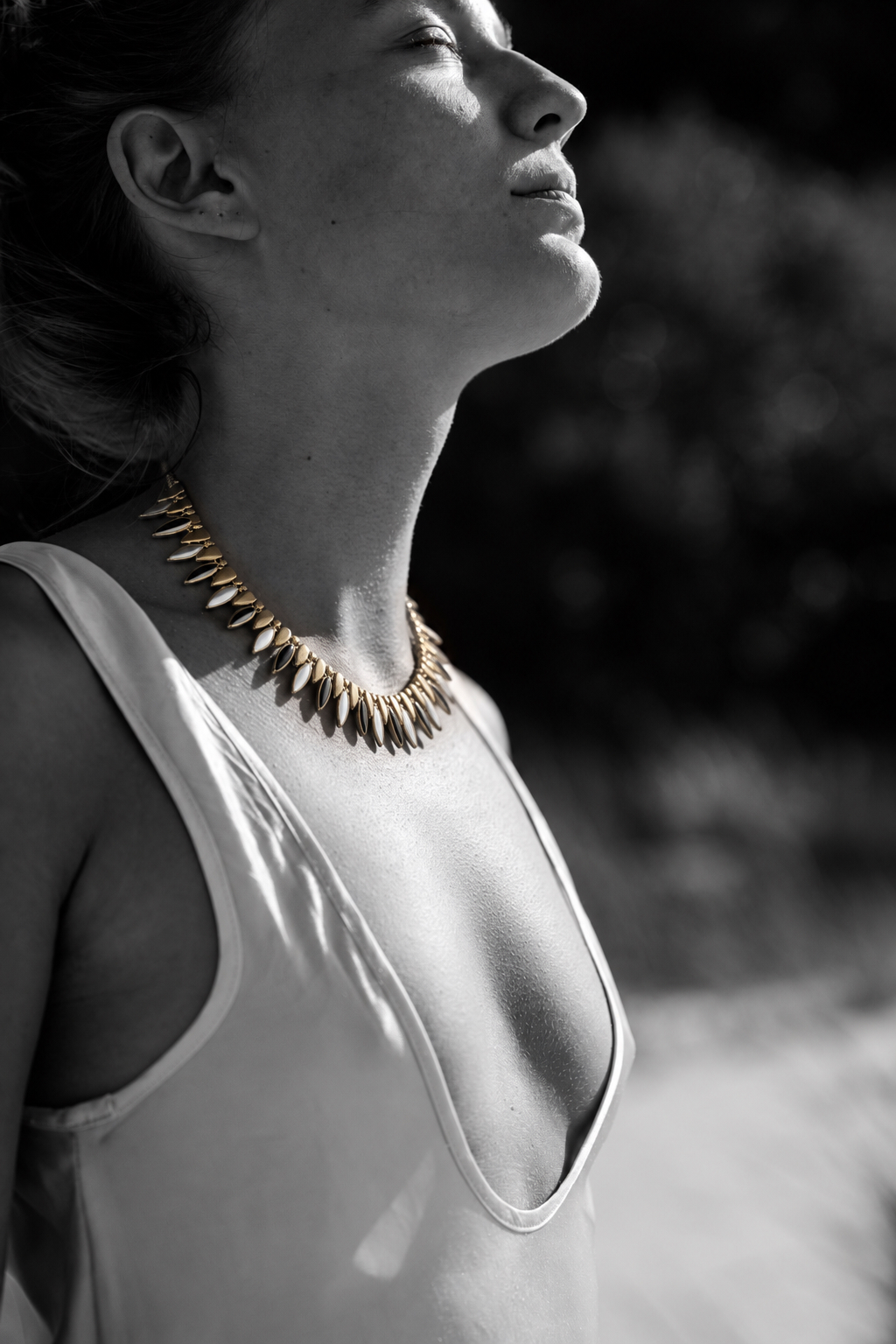 Sculptural gold necklace in a black-and-white portrait